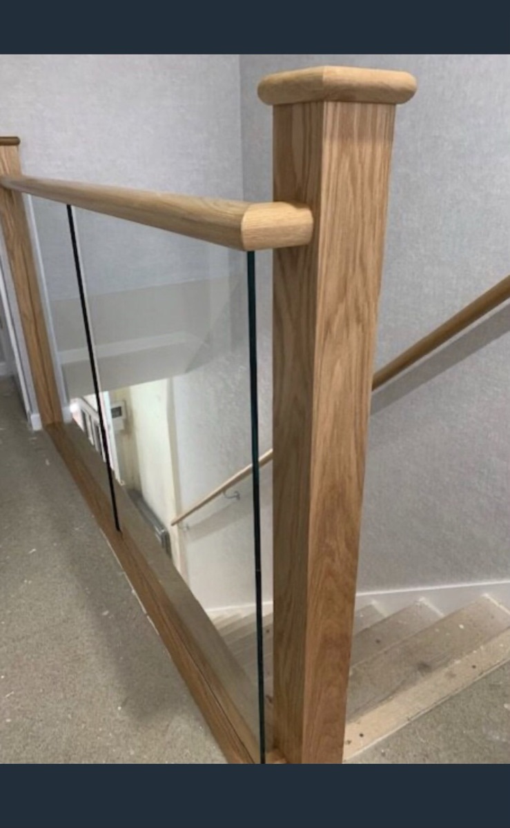 Oak and frameless glass balustrade running along a first-floor landing