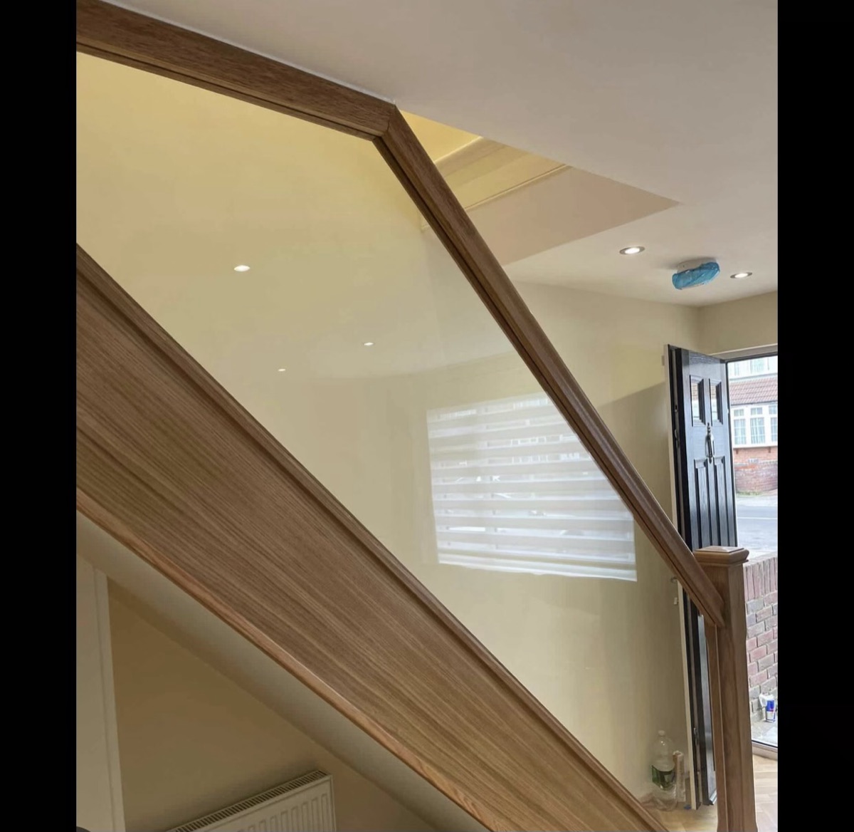 Raked oak and glass balustrade following the pitch of a bright landing
