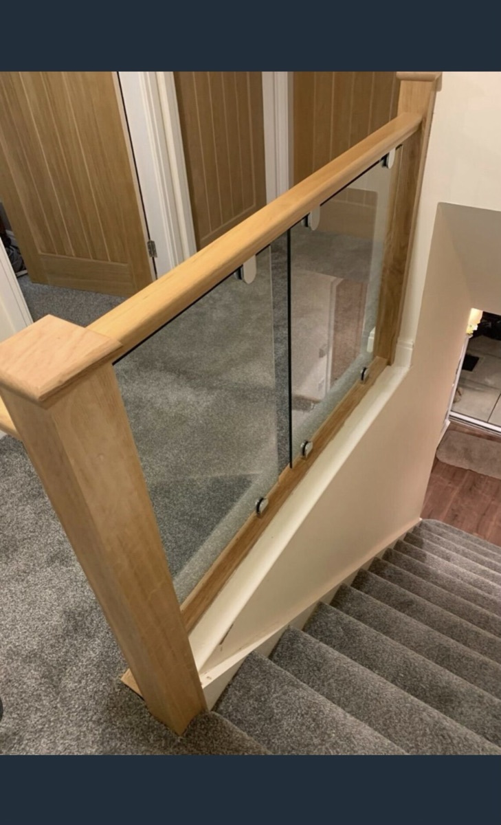 Solid oak newel post with clamped frameless glass balustrade infill
